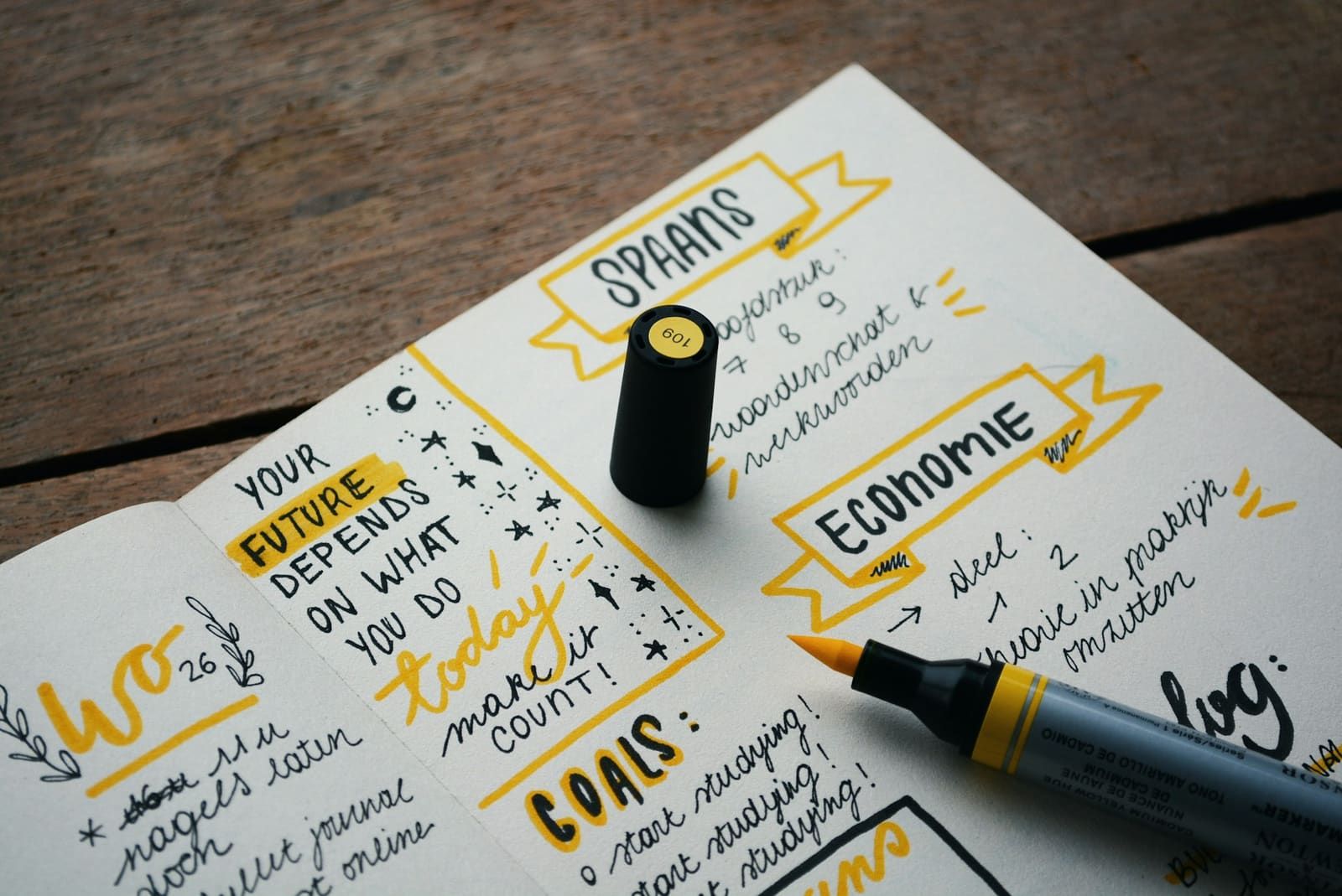 A study planner spread open on a table, with goals hand-lettered in black and yellow marker.